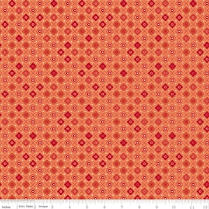 May include: Orange fabric with a repeating pattern of red and white floral and cross designs. The fabric is measured in inches, with a scale at the bottom. The Riley Blake Designs logo is visible.