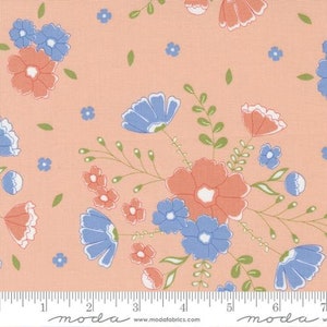 May include: Peach-colored fabric with a floral pattern featuring blue and coral flowers. The fabric has a subtle texture and is printed with a repeating pattern of flowers and leaves. The fabric is marked with a ruler and the words "moda" and "www.modafabrics.com".