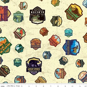 May include: A beige fabric with a repeating pattern of colorful national park patches. The patches feature names of parks like Yosemite, Glacier, Zion, and Rocky Mountain. Each patch has a unique design with illustrations of animals, mountains, and other natural features.