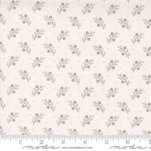 May include: White fabric with a repeating pattern of small gray sprigs with tiny flowers. The fabric is marked with a ruler in inches.