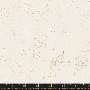 May include: White fabric with a scattered gold and white speckled pattern. The fabric is marked with a ruler in inches and the text "RUBY STAR SOCIETY".