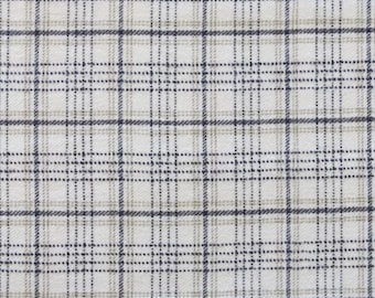 May include: Close-up of a fabric with a plaid pattern. The design features a grid of intersecting lines in navy blue and light brown against a white background. The fabric has a woven texture.