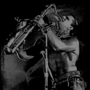 May include: A black and white photo of a person playing a saxophone. The person is wearing a shirt and pants. The saxophone is held in front of the person's face.