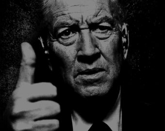 May include: A black and white portrait of a man with a serious expression. He is wearing a suit and tie and giving a thumbs up.