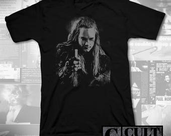 May include: Black t-shirt featuring a white graphic print of a man with long hair. The graphic is a close-up of the man's face and shoulders. The text "CULT RATED" is printed in white on a black rectangle at the bottom of the image.