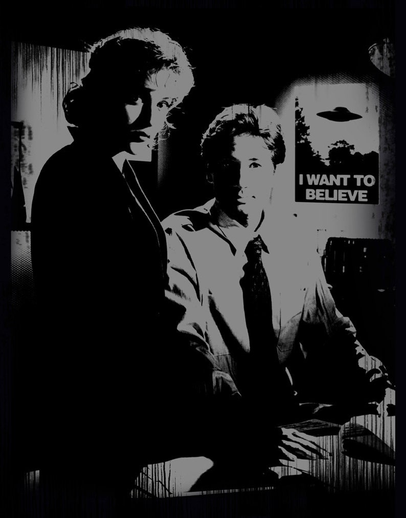 Puede incluir: Imagen en blanco y negro de dos personas, una mujer y un hombre, de pie frente a un cartel que dice "I WANT TO BELIEVE". El cartel tiene un dibujo de un platillo volante.