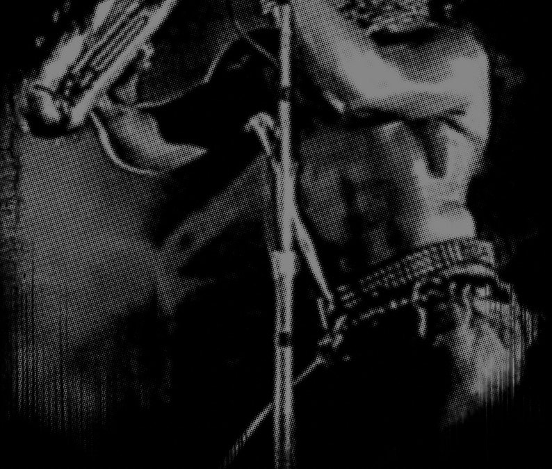 May include: A black and white photo of a person playing a musical instrument. The person is holding a microphone in their right hand and the instrument in their left hand. The person's face is partially obscured by the microphone.