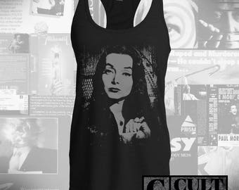 May include: Black tank top with a white graphic print of a woman with long dark hair. The graphic is a close-up of the woman's face and shoulders. The text "CULT RATED" is printed in white on a black background at the bottom of the image.