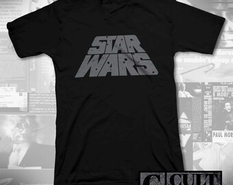 May include: Black V-neck t-shirt featuring the Star Wars logo in grey. The logo is centrally positioned. The shirt also has the text "CULT RATED" in the bottom right corner.