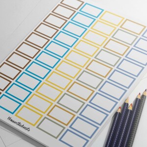 Könnte beinhalten: Ein Blatt mit leeren rechteckigen Aufklebern mit braunen, blauen, gelben und grauen Rändern. Die Aufkleber sind in vier Reihen angeordnet.