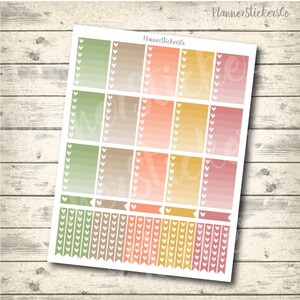 Op de afbeelding: Een vel planner stickers met een verloop in groen, bruin, oranje en roze. De stickers hebben witte hartjes langs de randen en zijn in een rasterpatroon gerangschikt. De tekst "Planner StickersCo" staat bovenaan het vel.