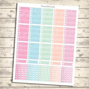 Op de afbeelding: Een vel pastelkleurige planner stickers met hartvormige vinkjes. De stickers zijn in roze, blauw, groen en oranje. De stickers zijn gerangschikt in een rasterpatroon. De tekst "Planner StickersCo" staat bovenaan het vel gedrukt.