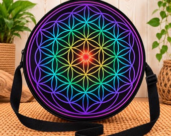 May include: A round crossbody bag featuring a vibrant, multicolored flower of life geometric pattern on a black background. The design transitions through a spectrum of colors, including red, yellow, green, blue, and purple, with a bright red center.