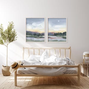 a bedroom with a bed and two paintings on the wall