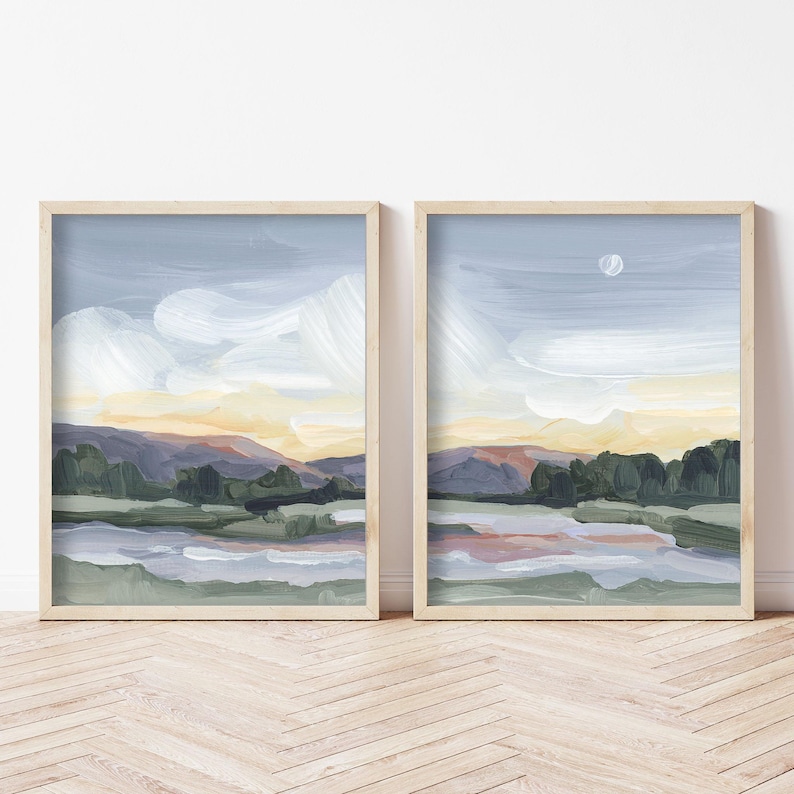 two framed paintings of a landscape on a wall