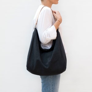 Große schwarze Hobo-Tasche mit Ledergriff. Leinen-Hobo-Tasche für den Sommer. Umhängetasche im lässigen Stil für den täglichen Gebrauch.