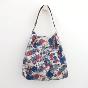 Leichte Hobo-Tasche aus Stoff mit Blumendruck, Ledergriff und optionalem Reißverschluss. Lässige Sommer-Boho-Tasche in Kastanienbraun- und Blautönen.