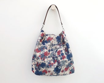 Lightweight floral print fabric hobo bag with leather strap and optional zipper. Casual boho summer handbag in burgundy and blue.