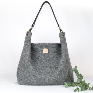 Minimalista bolso hobo de lana gris claro. Bolso de hombro grande y ligero con asa de cuero.