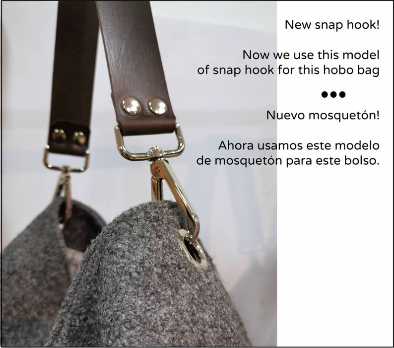 May include: Close-up of a brown leather strap with silver snap hooks attached to a gray felt hobo bag. The text "New snap hook!" and "Now we use this model of snap hook for this hobo bag" is visible in the image.