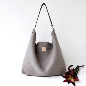 Taupefarbene Hobo-Schultertasche. Hellbraune Wolltasche mit Ledergriff.