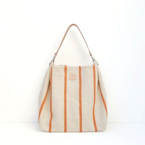 Lässige Canvas-Tasche für den Sommer. Große Tasche mit Ledergriff. Orange und beige gestreifte Hobo-Tasche.