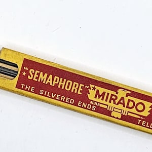 May include: A box of "Semaphore" Mirado leads for mechanical pencils. The box is yellow with red lettering and an eagle graphic. The text on the box reads "Semaphore" Mirado Leads, The Silvered Ends Tell When To Refill."