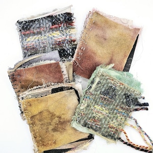 May include: A collection of fabric scraps in various colors and textures, including brown, green, and black. The fabric scraps are arranged in a pile and have frayed edges.