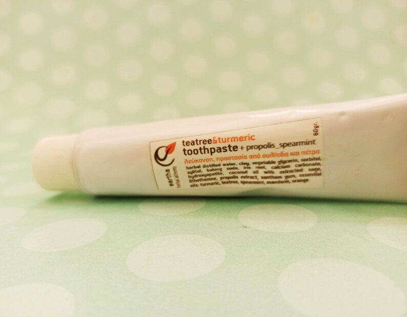 May include: A white tube of teatree & turmeric toothpaste with propolis and spearmint. The tube is labeled with the product name, ingredients, and benefits. The tube is 60 grams.