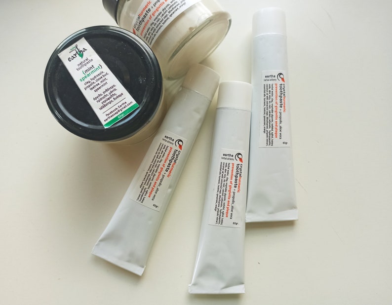 May include: Three tubes of natural toothpaste with labels that read "Earth Natural Toothpaste - Turmeric Toothpaste - Propolis Aloe Vera - Prevention of gingivitis and plaque".  One jar of natural toothpaste with a label that reads "Earth Natural Toothpaste (Mint Spearmint)".