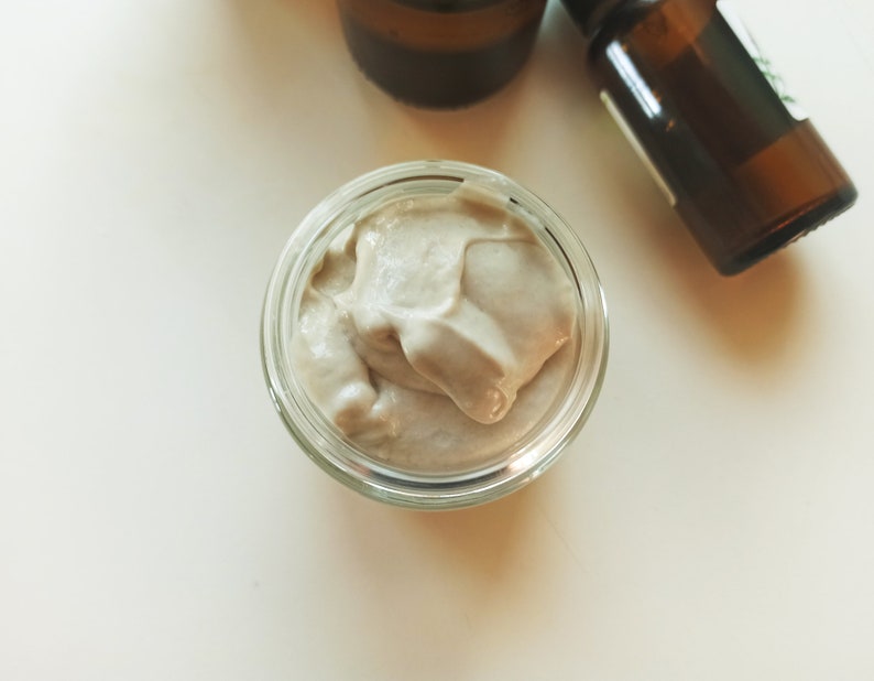 May include: A small glass jar filled with a light brown, creamy substance. The substance has a smooth, whipped texture.