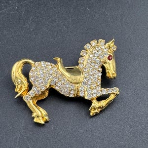 Vintage clear crystal rhinestone horse brooch, gold tone