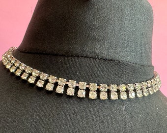 May include: A silver choker necklace with a double row of clear rhinestones.