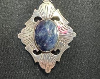 May include: A silver pendant necklace with a blue gemstone set in a decorative, ornate frame.