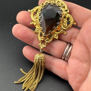Vintage 11cm gold tone tassel brooch with brown cognac glass central cabochon.