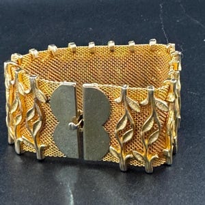 Vintage gold tone 3.5cm wide woven flat articulated Mesh bracelet 18.5cm long with floral detail