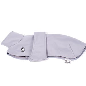 May include: A light gray dog coat featuring a smooth, solid-colored exterior, a high collar, and a wide adjustable strap across the midsection. A small circular logo with a dog silhouette is on the side, and a rectangular brand tag is attached.