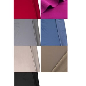 May include: A collection of seven fabric swatches in various solid colors including deep red, vibrant magenta, slate gray, dusty blue, light beige, warm taupe, and solid black. Each piece of textile displays a smooth, matte finish and folds.