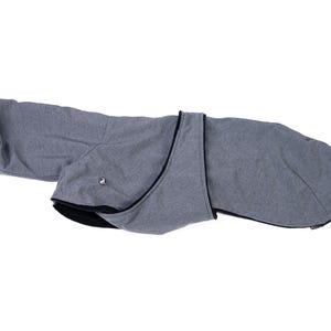 May include: A grey dog coat featuring a textured heathered fabric exterior with a solid black interior lining. The garment includes a wrap-around design with a small metallic fastener detail on the side and black trim along the edges.