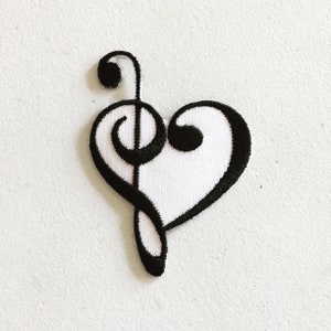 May include: Black embroidered iron-on patch of a treble clef in the shape of a heart.