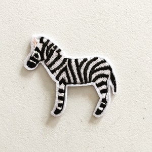 May include: An iron-on patch featuring a black and white embroidered zebra.