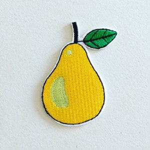Pode incluir: Uma pêra bordada amarela com uma folha verde. A pêra tem uma mancha verde claro no lado.