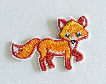 May include: Embroidered patch featuring a cartoon fox in shades of orange, red, and white. The fox is depicted in a walking pose with a fluffy tail and a friendly expression. The patch has a white border.