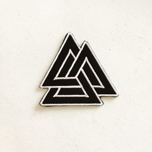 May include: Black and white embroidered patch of a triple triangle symbol, also known as the Valknut.