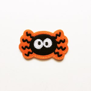 May include: Orange felt spider patch with black embroidered eyes and legs.