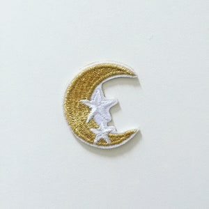 May include: A gold crescent moon embroidered patch with two white stars.