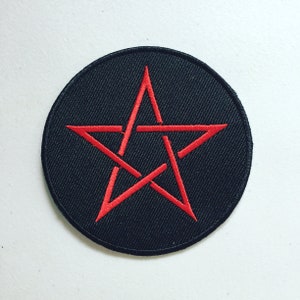 Peut inclure: Un écusson rond noir avec un pentagramme rouge brodé. L'étoile à cinq branches est centrée sur le patch, probablement en tissu. Le design est détaillé et frappant.