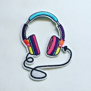 May include: An embroidered patch depicting a pair of headphones with a cord. The headphones are purple, pink, yellow, and blue. The cord is black and white.