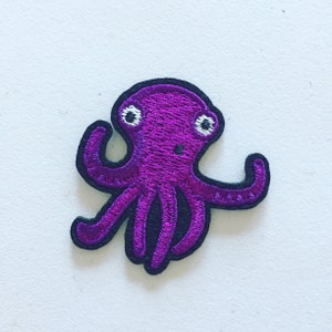 May include: Purple embroidered octopus patch with white eyes.