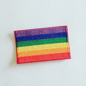 May include: A rainbow-colored embroidered patch with six stripes of red, orange, yellow, green, blue, and purple.